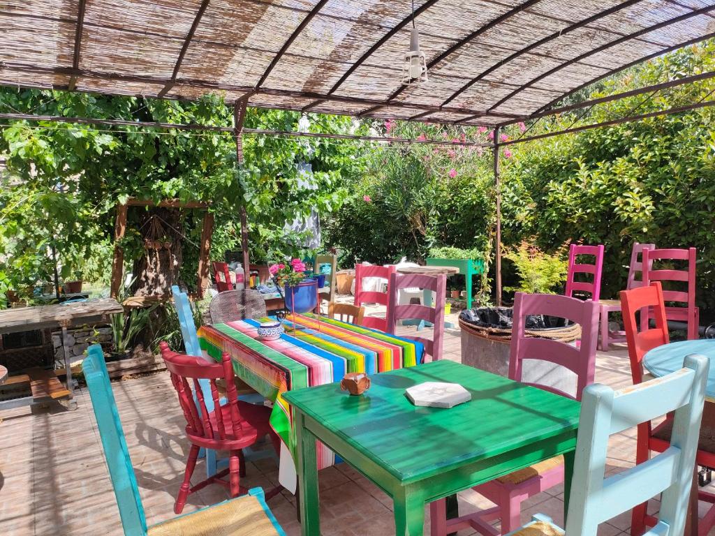 a patio with a table and chairs under a pergola at Les p'tits vélos in Chandolas