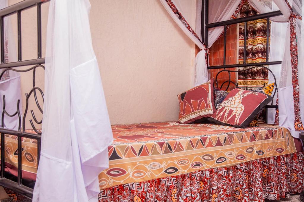 ein Zimmer mit einem Bett mit Kissen darauf in der Unterkunft JET VILLAS ENTEBBE ( JVE ) in Entebbe