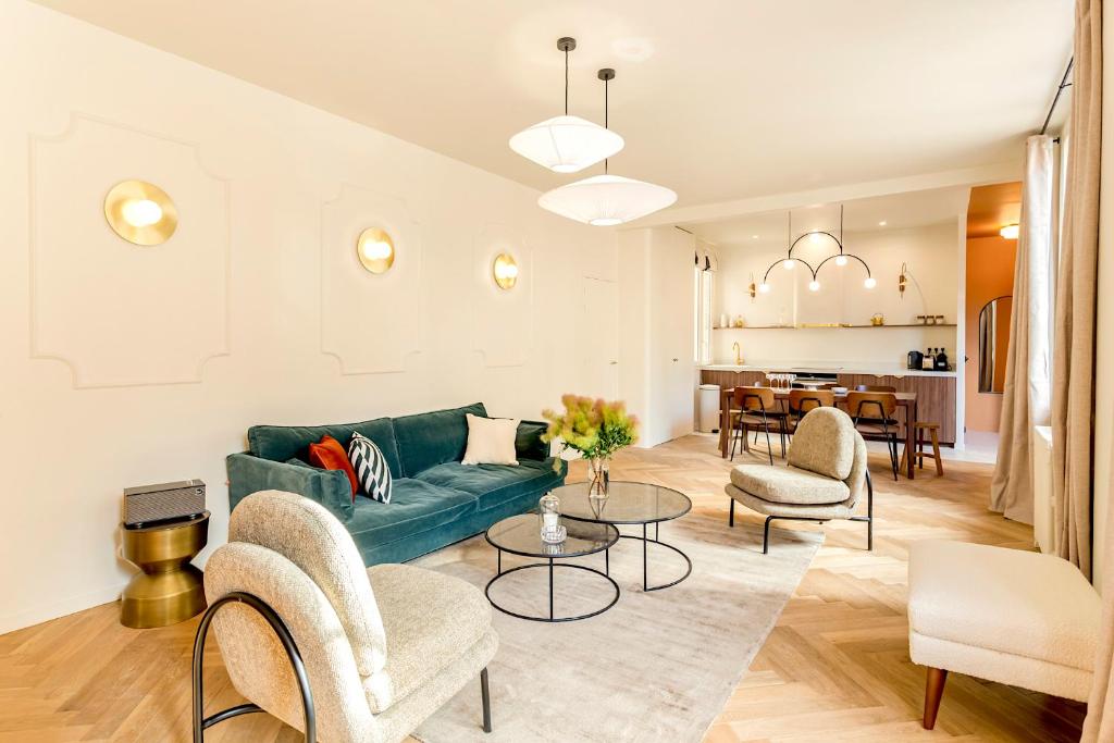 a living room with a green couch and chairs at Habitat Parisien - Bourse Feydeau in Paris