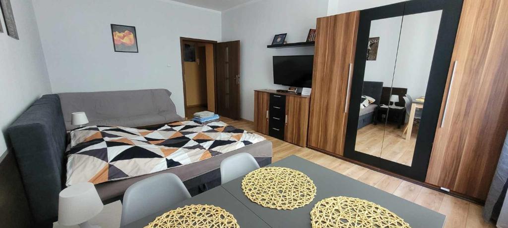 - un petit salon avec un lit et un miroir dans l'établissement Apartament Skwer Kosciuszki Morze, à Gdynia
