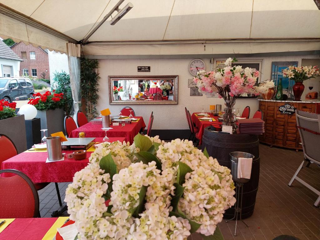 um restaurante com mesas vermelhas e flores brancas em Tapas restaurante 1 em Viersen