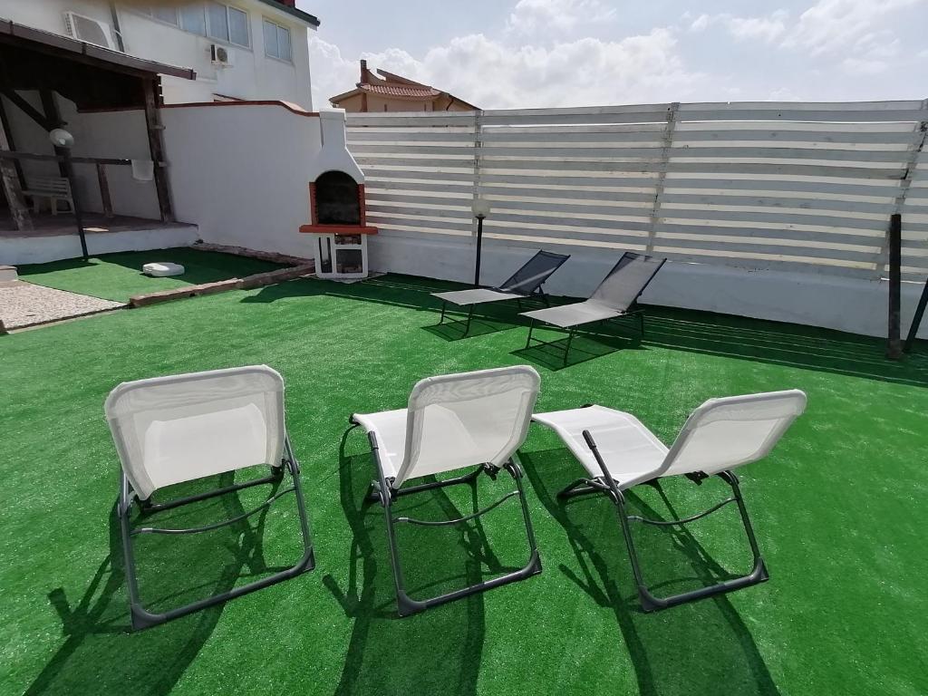 a group of chairs sitting on a green lawn at VILLA HEMINGWAY - LA CASA DI LEONARDO in Ficarazzi