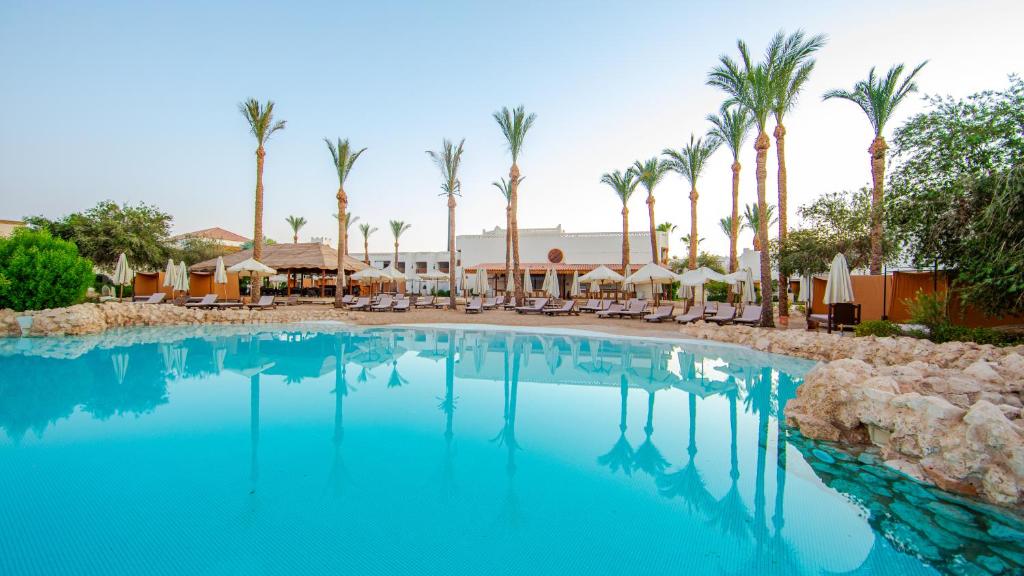 a swimming pool at a resort with palm trees at Ghazala Gardens in Sharm El Sheikh