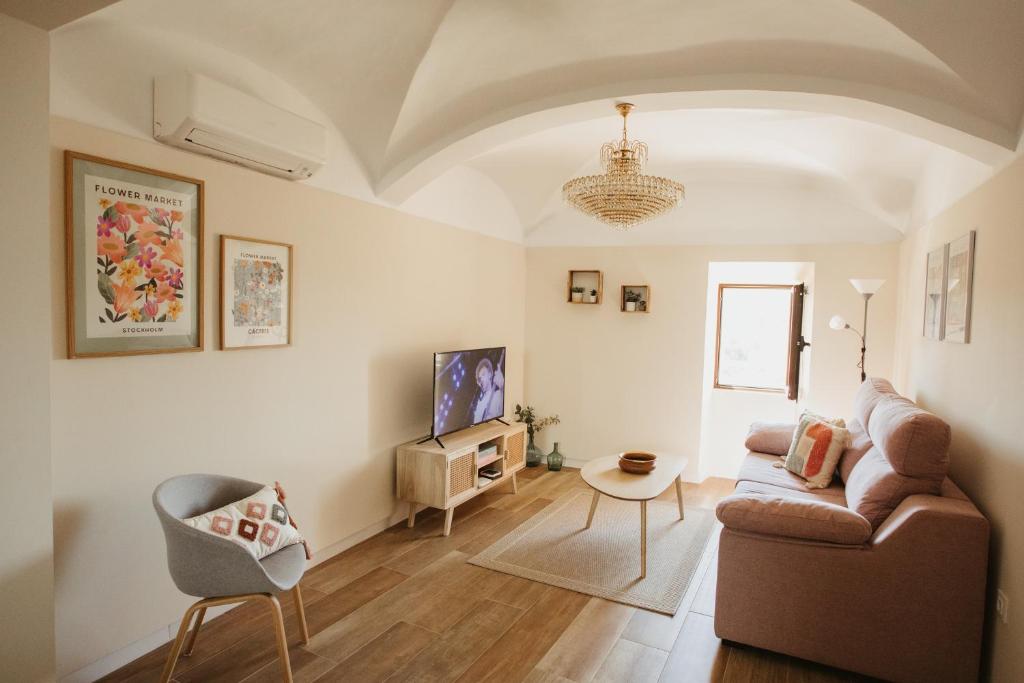 sala de estar con sofá y silla en Apartamento Baluarte de los Pozos, en Cáceres