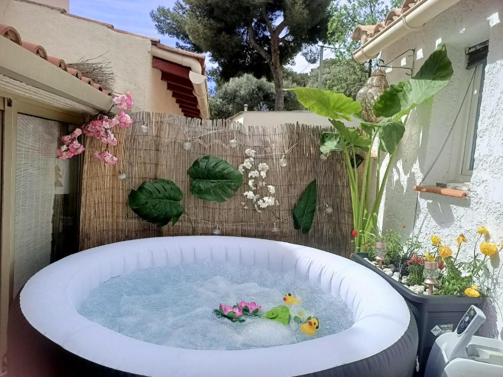 un bain à remous dans un jardin fleuri dans l'établissement MARTIGUES Adorable petite guest house, à Martigues