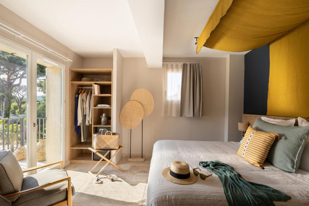 a bedroom with a bed with a bird sitting on it at Hôtel L'Escalet in Ramatuelle