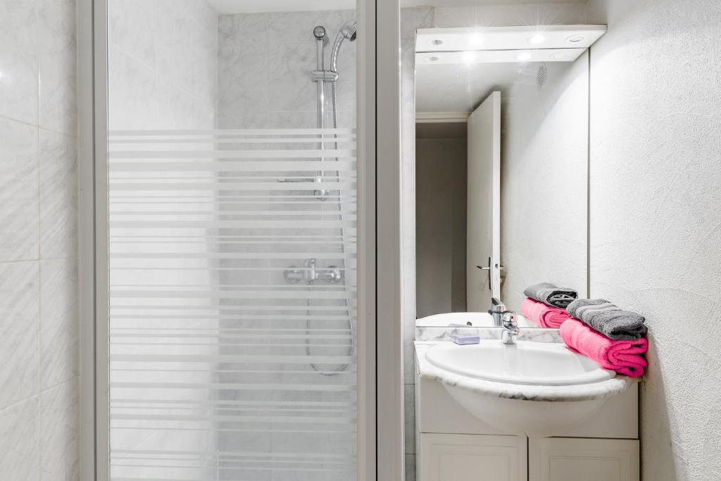 a white bathroom with a sink and a shower at Lagrange Vacances Le Scarlett et Les Soleillades in Palavas-les-Flots