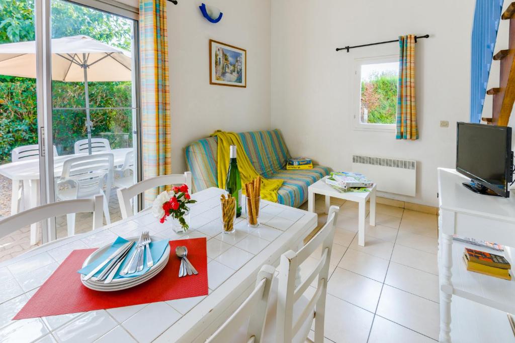 a living room with a table and a couch at Lagrange Vacances Le Scarlett et Les Soleillades in Palavas-les-Flots