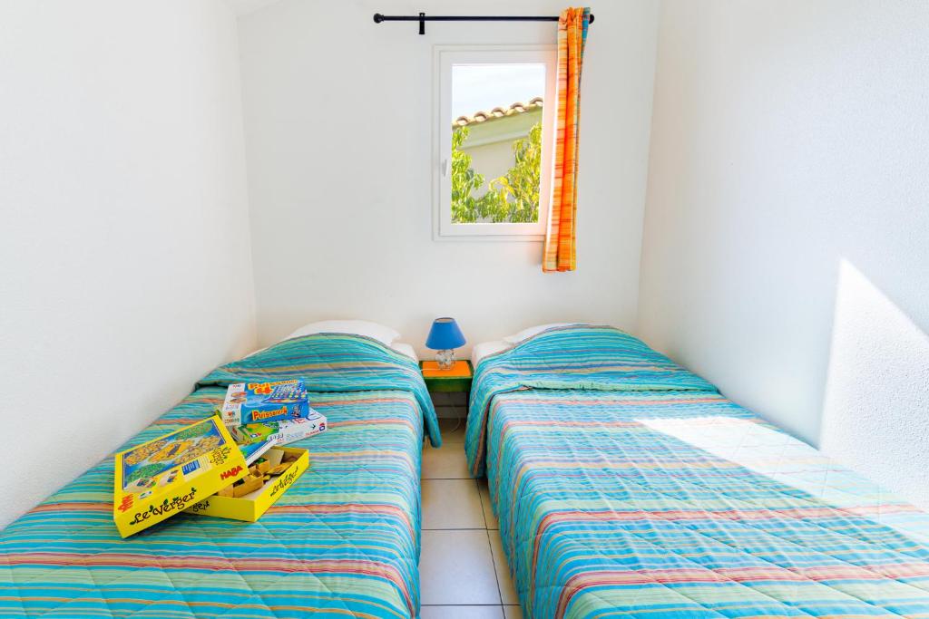 a bedroom with two twin beds and a toy truck at Lagrange Vacances Le Scarlett et Les Soleillades in Palavas-les-Flots