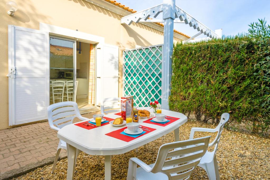 a white table and chairs on a patio at Lagrange Vacances Le Scarlett et Les Soleillades in Palavas-les-Flots