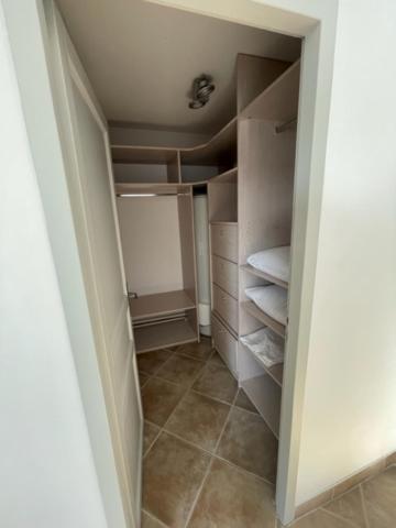 a walk in closet with white cabinets and a tile floor at Résidence quai St Louis Villa t4 pour 6 personnes N1 47 in Aigues-Mortes
