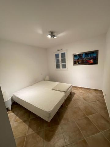 a bedroom with a white bed in a room at Résidence quai St Louis Villa t4 pour 6 personnes N1 47 in Aigues-Mortes