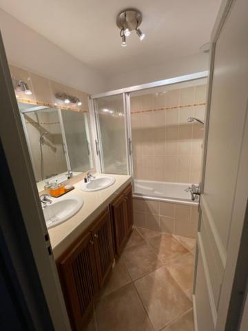 a bathroom with two sinks and a shower and a tub at Résidence quai St Louis Villa t4 pour 6 personnes N1 47 in Aigues-Mortes
