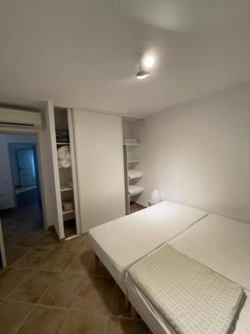 a white room with a bed and a room with shelves at Résidence quai St Louis Villa t4 pour 6 personnes N1 47 in Aigues-Mortes