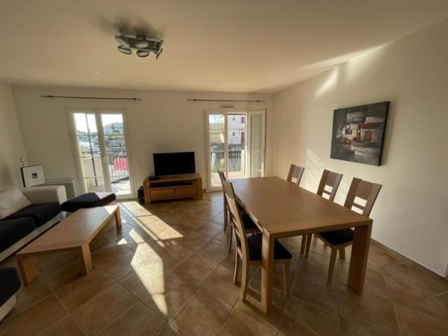 a living room with a table and a couch at Résidence quai St Louis Villa t4 pour 6 personnes N1 47 in Aigues-Mortes