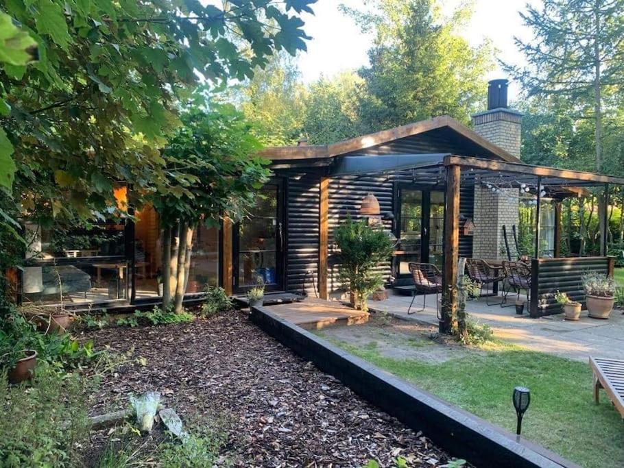 um pavilhão de madeira num jardim com um banco em Sommerhus med sjæl em Egå