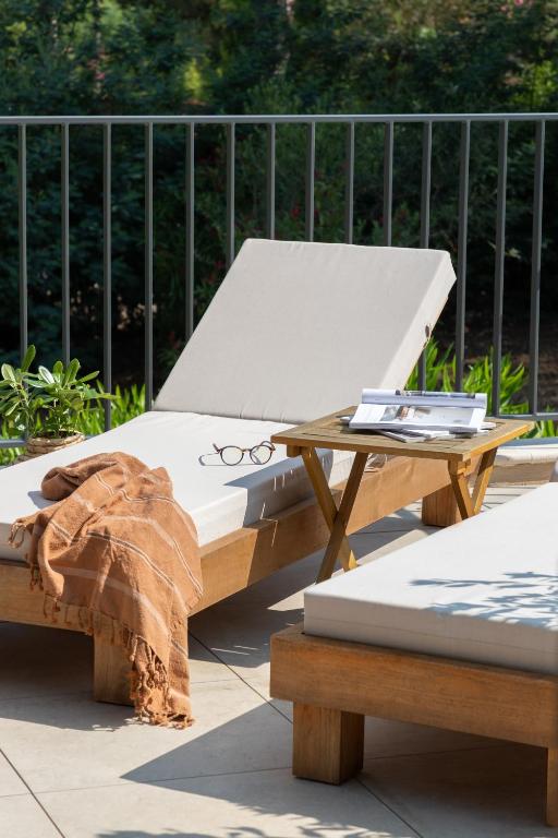 a bed and a table with a pair of glasses on it at Hôtel L'Escalet in Ramatuelle