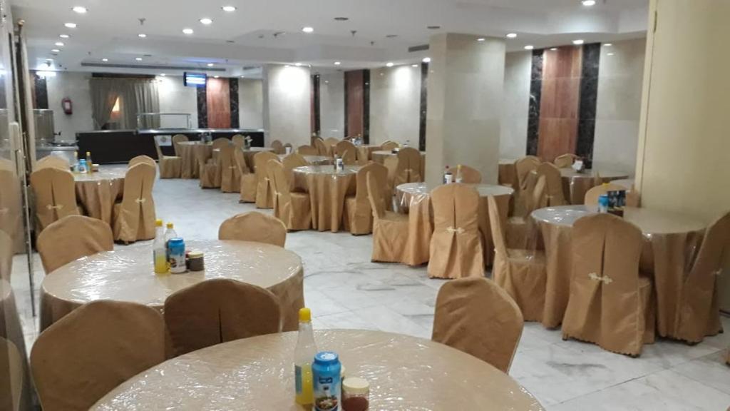 فندق روابي العزيزية-Rawaby Hotels في مكة المكرمة: قاعة احتفالات مع طاولات وكراسي وغرفة بها