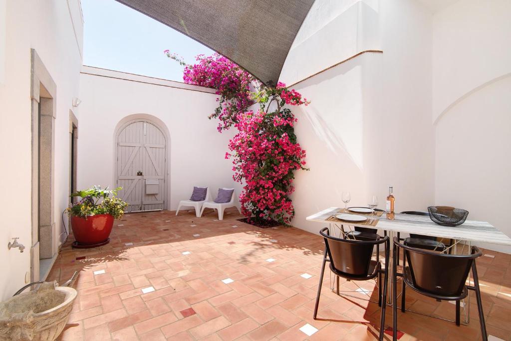 a room with pink flowers and a table and chairs at Casa Rosa in São Brás de Alportel