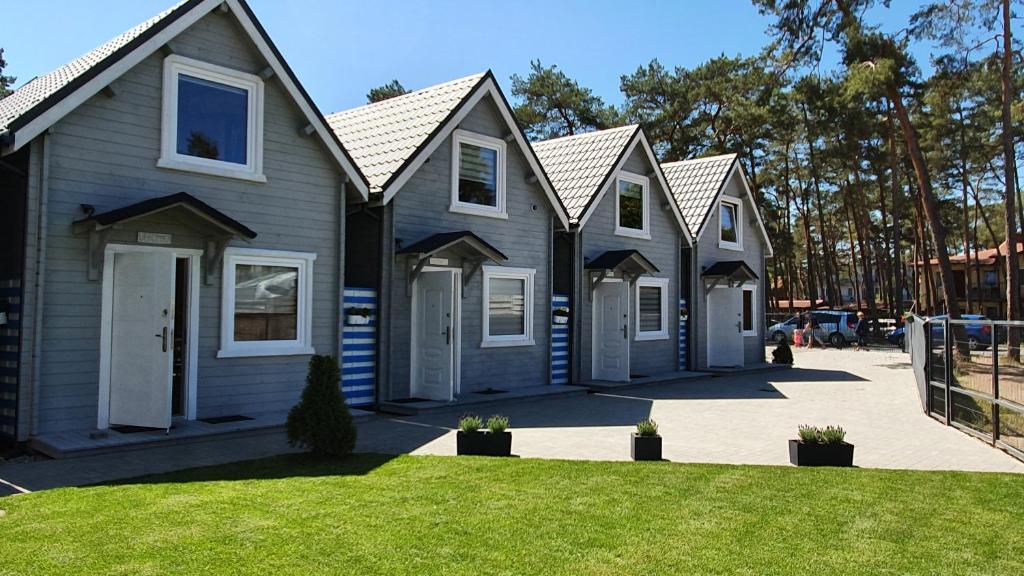 a row of houses in a yard with grass at Domki Polarne in Dziwnówek