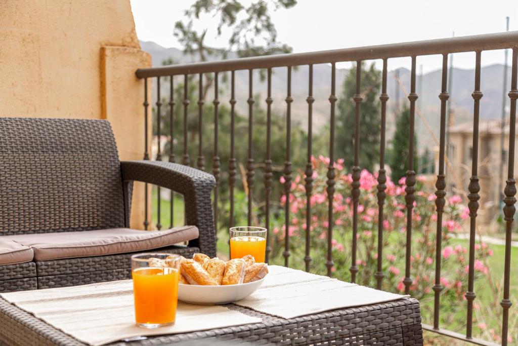- une table avec un bol de pain et deux verres de jus d'orange dans l'établissement Trendy Homes Envia Golf I, à La Envia