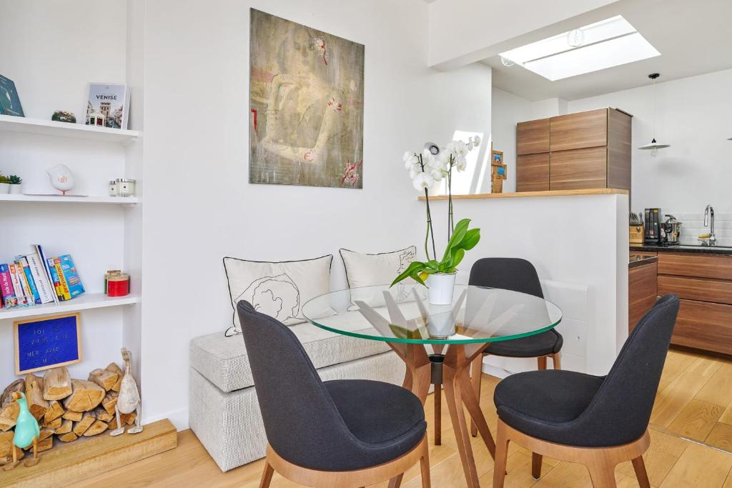 une salle à manger avec une table et des chaises en verre dans l'établissement Appartement des Sèvres - Welkeys, à Paris