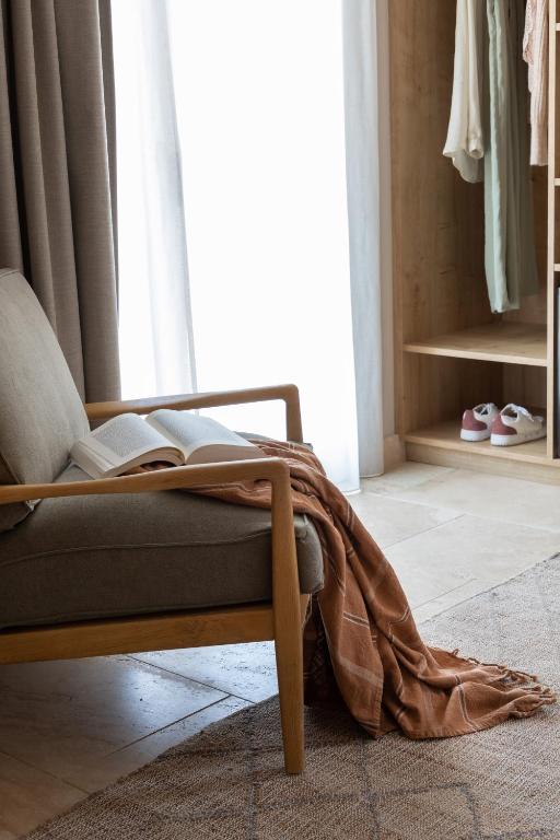 a room with a chair with a book on the floor at Hôtel L'Escalet in Ramatuelle