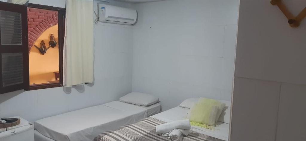 Porto Cajá by VM في بورتو دي غالينهاس: غرفة بيضاء مع سرير ونافذة