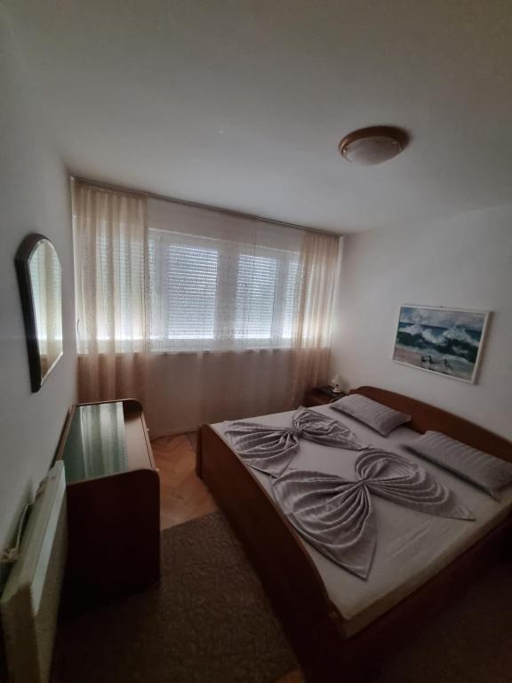 ein Schlafzimmer mit einem großen Bett und einem Fenster in der Unterkunft Drago Apartman in Šibenik