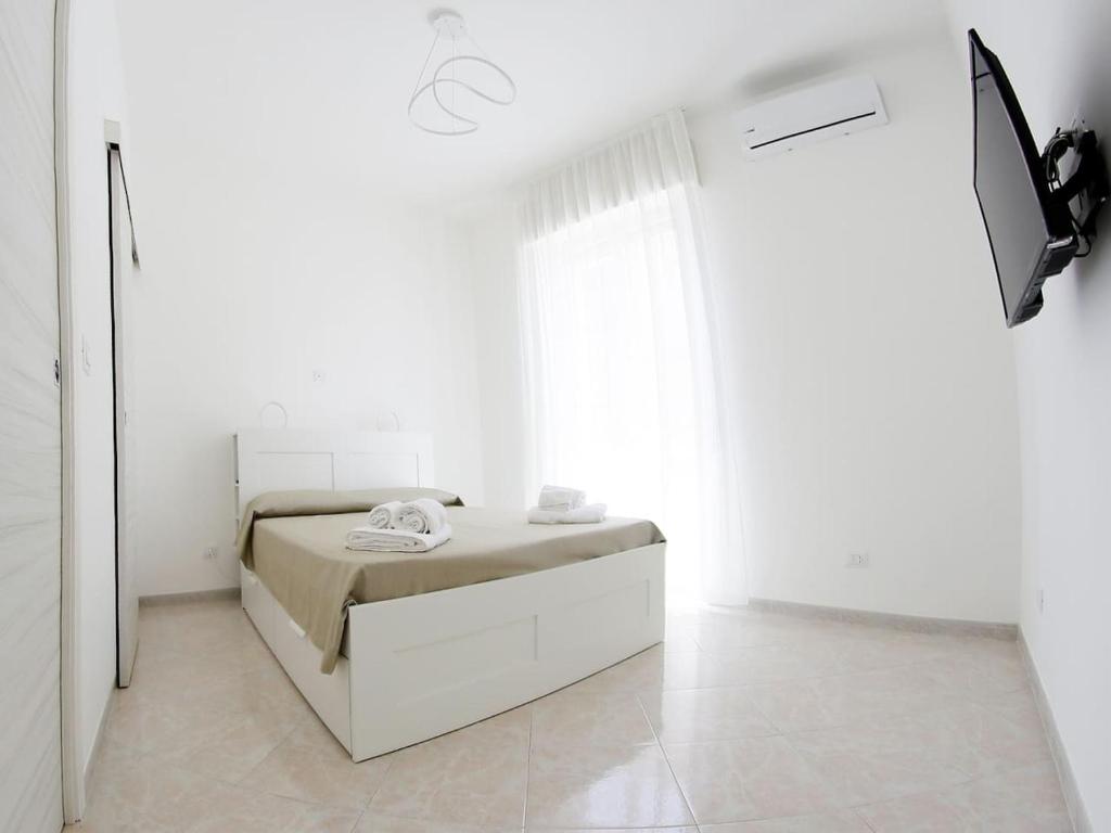 ロゾリーニにあるSikelia holiday houseの白いベッドルーム(ベッド1台、窓付)