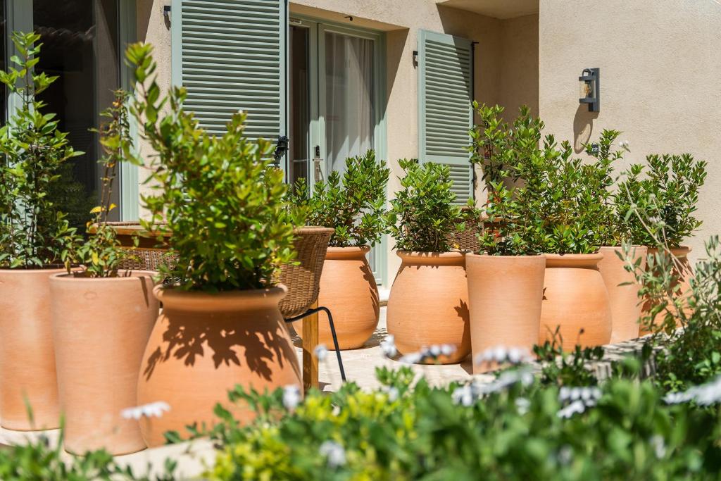 a row of orange pots with plants in them at Hôtel L'Escalet in Ramatuelle