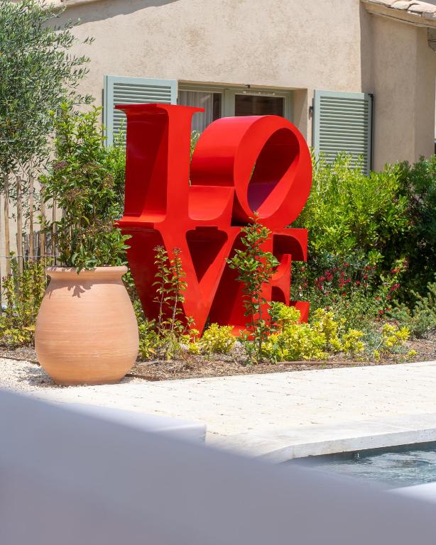 a large red sign in front of a building at Hôtel L'Escalet in Ramatuelle