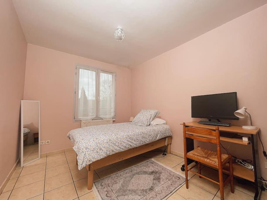 - une chambre avec un lit et un bureau avec une télévision dans l'établissement La Perle Rose ONLY WOMEN femmes uniquement, à Vénissieux