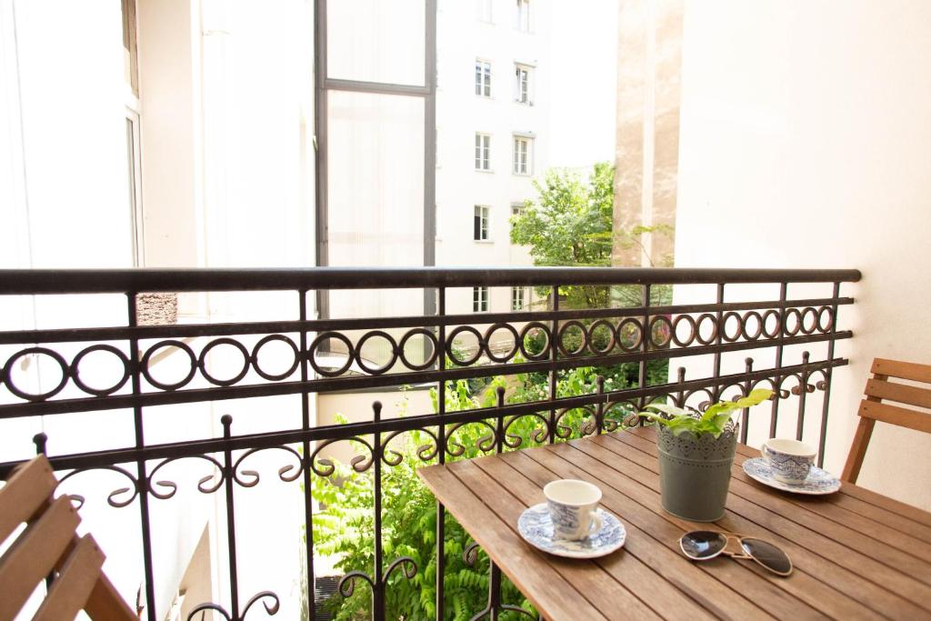 a table on a balcony with a view of a city at City Center - Cozy And Bright - Dobra11 in Warsaw
