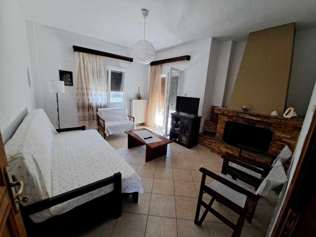 a bedroom with a bed and a living room with a fireplace at SUNDAY HOUSE in Skala Kallirakhis