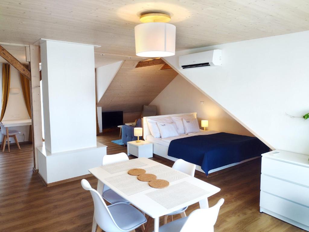um quarto com uma cama, uma mesa e cadeiras em Apartmán Kollarovi em České Budějovice