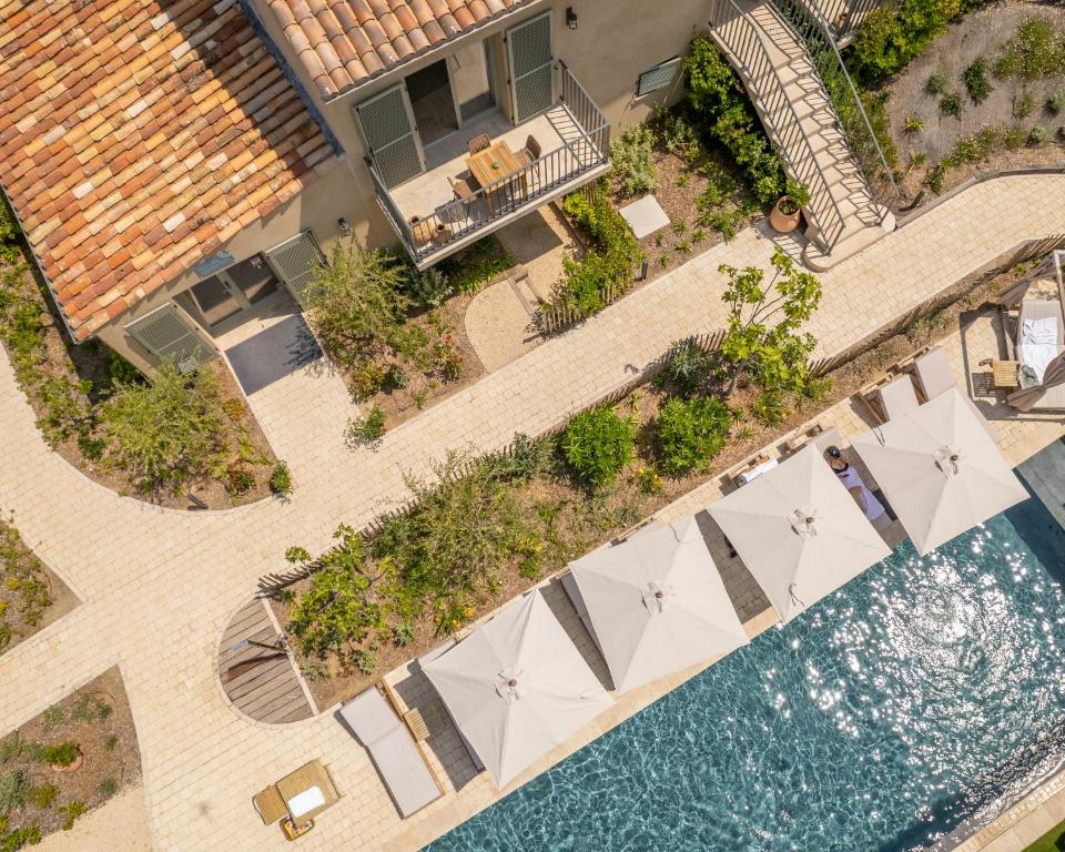 an overhead view of a pool with tables and umbrellas at Hôtel L'Escalet in Ramatuelle