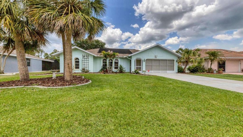 a house with palm trees in the yard at 26360 Copiapo in Port Charlotte