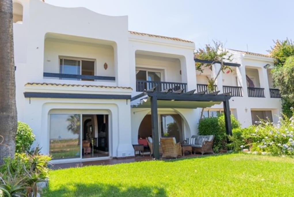 een wit huis met een balkon en een tuin bij Bord de mer, villa de luxe in Casablanca