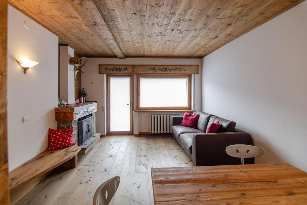 a living room with a couch and a wooden ceiling at Estate in montagna in San Vito di Cadore