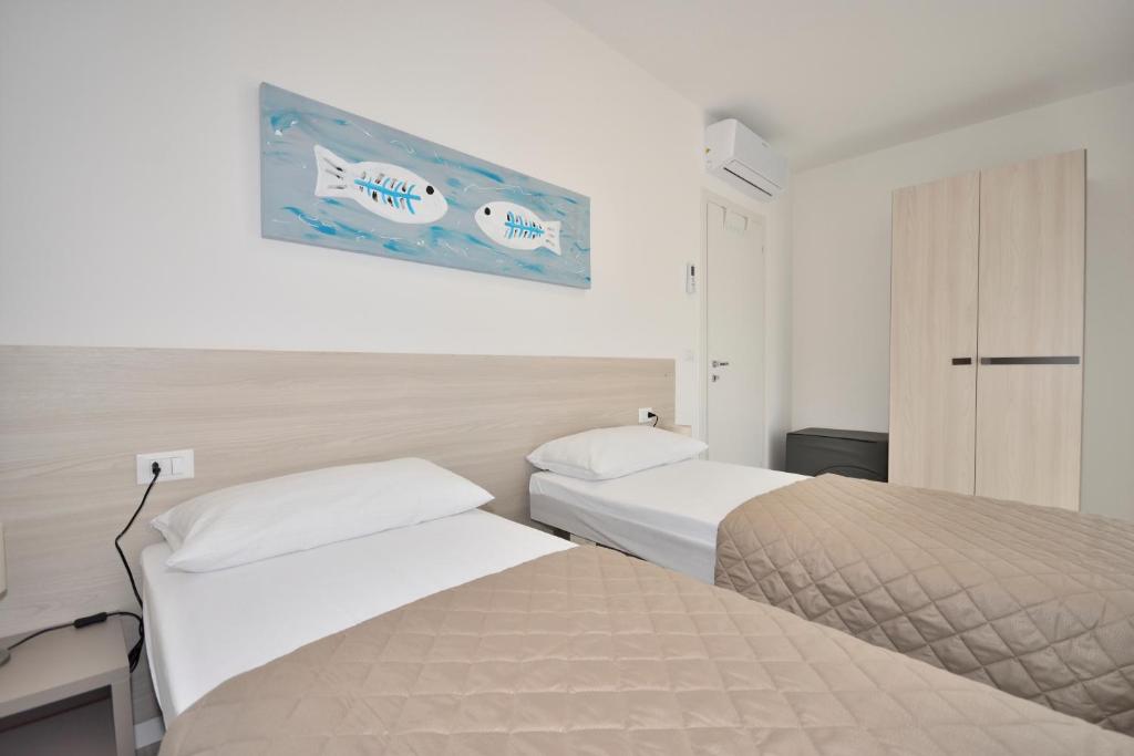 een hotelkamer met twee bedden en een foto aan de muur bij Condominio Aliante in Bibione
