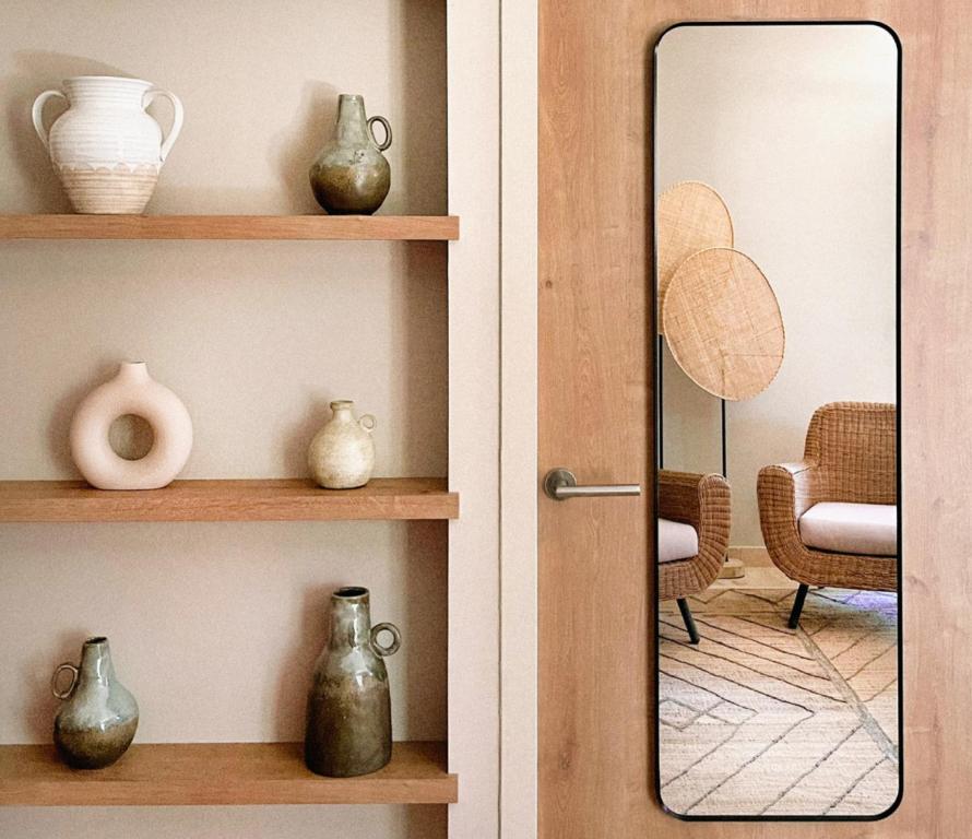 two pictures of a door with vases and a mirror at Hôtel L'Escalet in Ramatuelle
