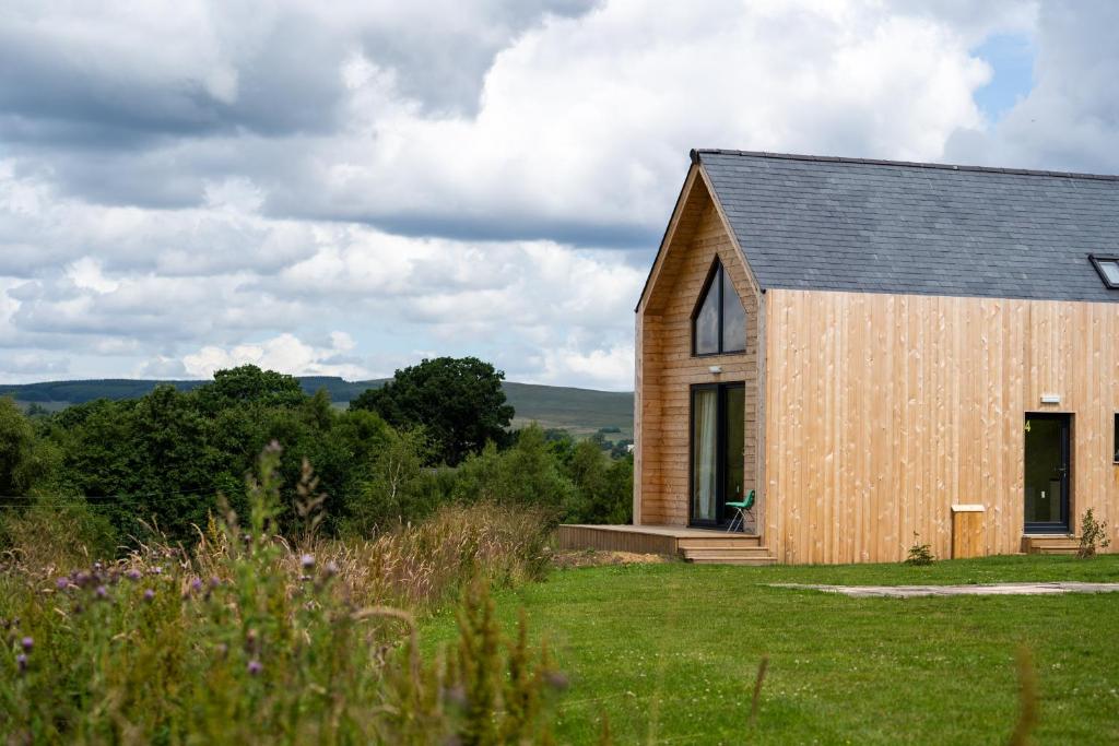 a wooden church with a gambrel roof at Tarset Tor - Bothy 2 in Hexham