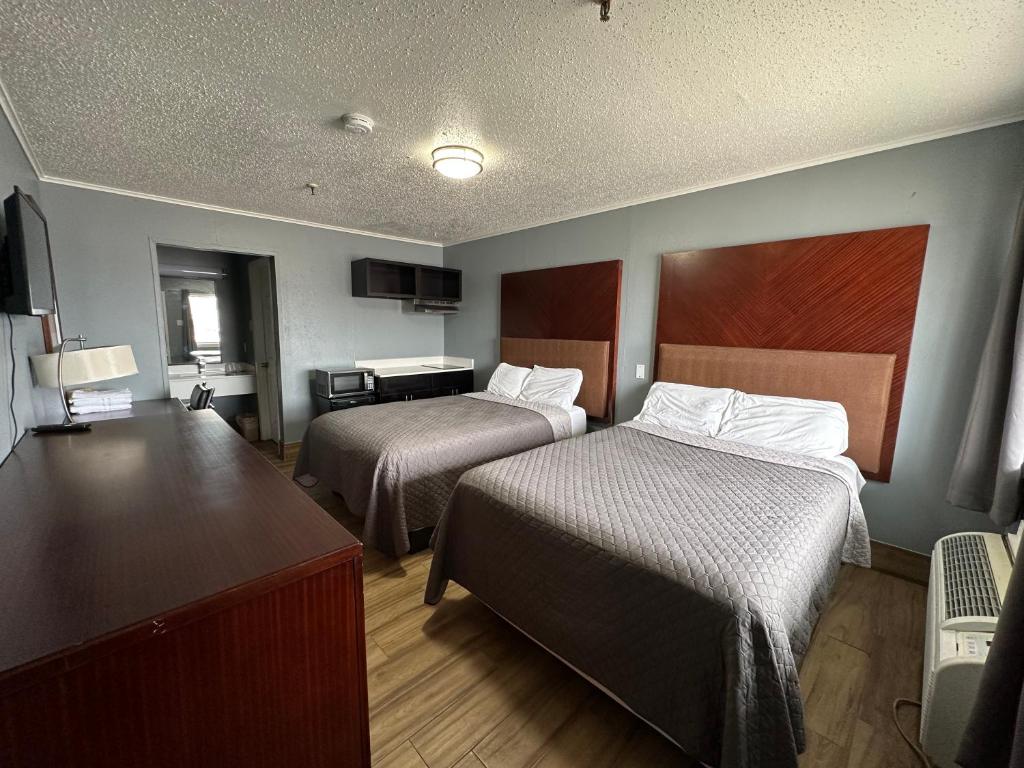 Cette chambre comprend deux lits et un bureau. dans l'établissement Studio Suites, à San Antonio