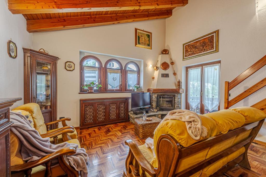 een woonkamer met een bank en een tv bij CASA BEATRICE - Wifi, Parcheggio e Vista Montagna - COUR 0231 in Courmayeur