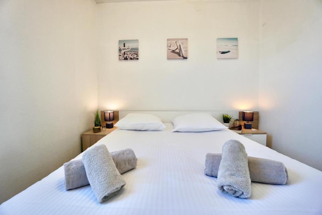ein Schlafzimmer mit einem großen weißen Bett mit drei Kissen in der Unterkunft La Lézardière *Front de mer* in Ploemeur