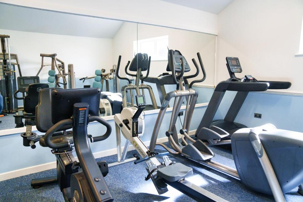 a gym with a bunch of cardio equipment in it at The Cliff Hotel & Spa in Cardigan