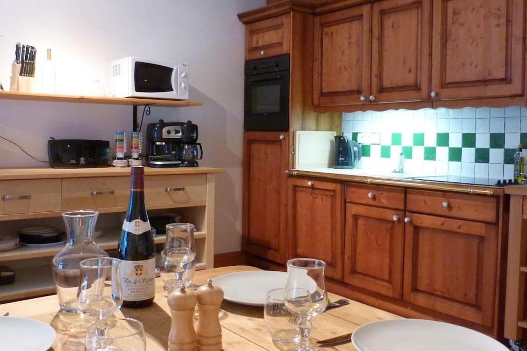 a kitchen with a table with glasses and a bottle of wine at Chataigne, cosy 3 bedroom apartment with great views in Sainte-Foy-Tarentaise