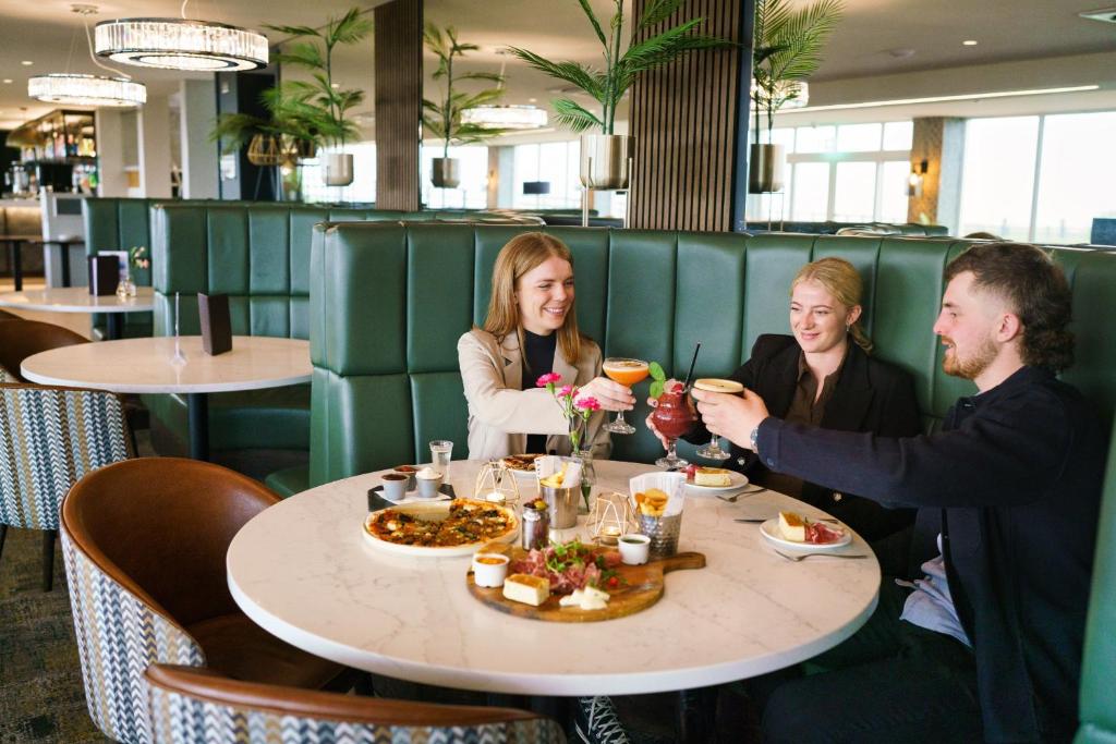 a group of people sitting around a table in a restaurant at The Cliff Hotel & Spa in Cardigan