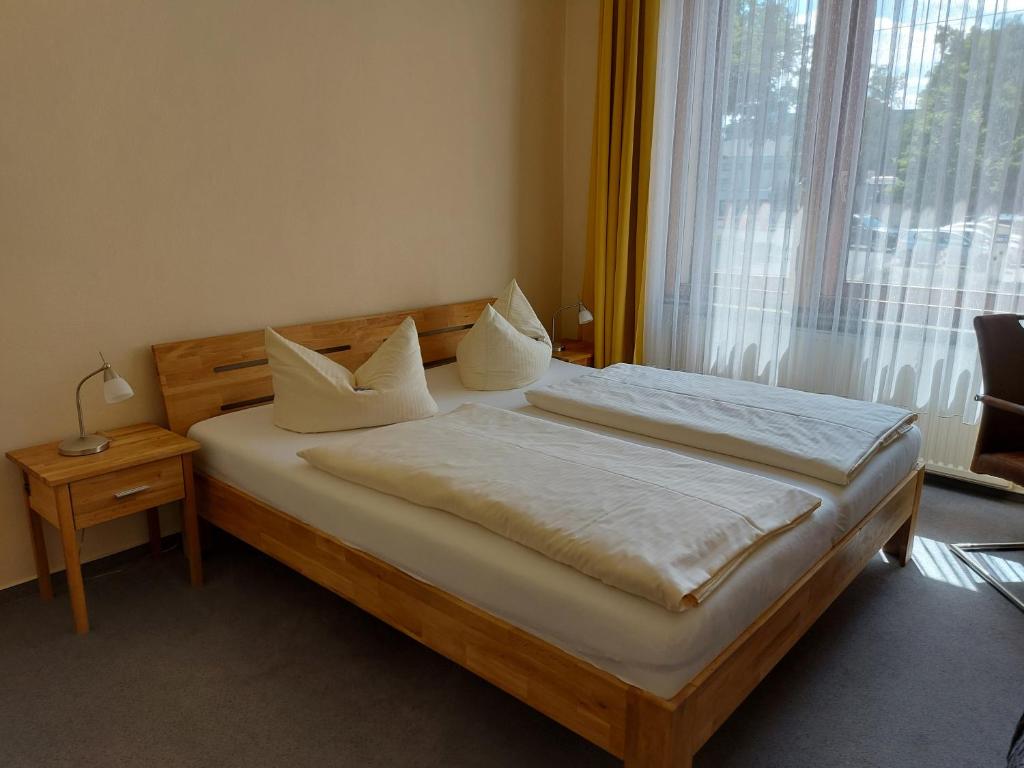 a bedroom with a bed with white pillows and a window at An der Stadthalle in Braunschweig